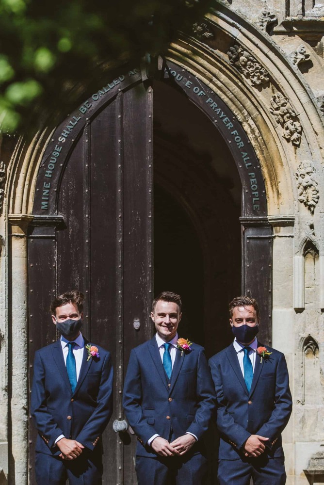 Groom with best man, wearing facemasks at wedding with covd-19 coronavirus restrictions