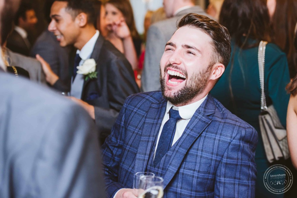 Wedding guests laugh and chat, during wedding reception